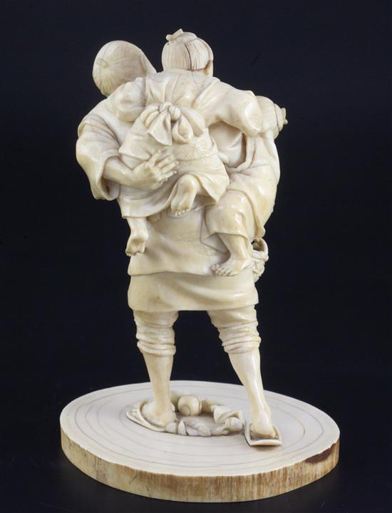 A Japanese ivory group of a man carrying two boys, Meiji period, height 16cm, age cracks and losses